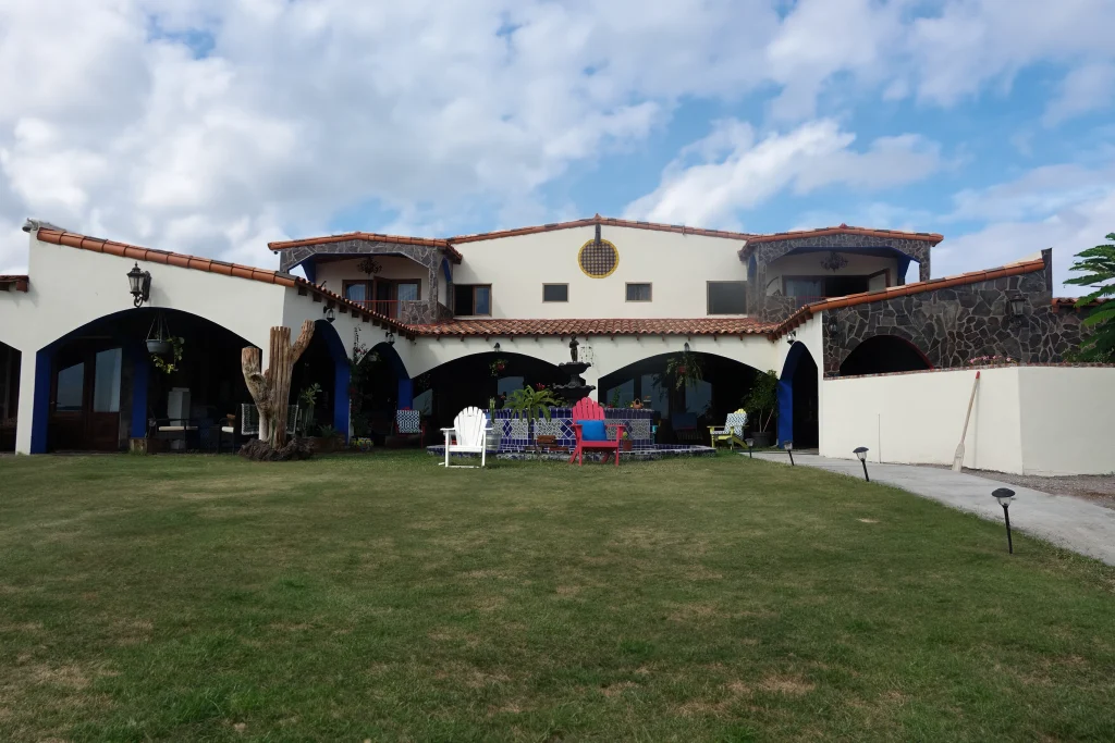 white terracotta mansion with big green grassy yard