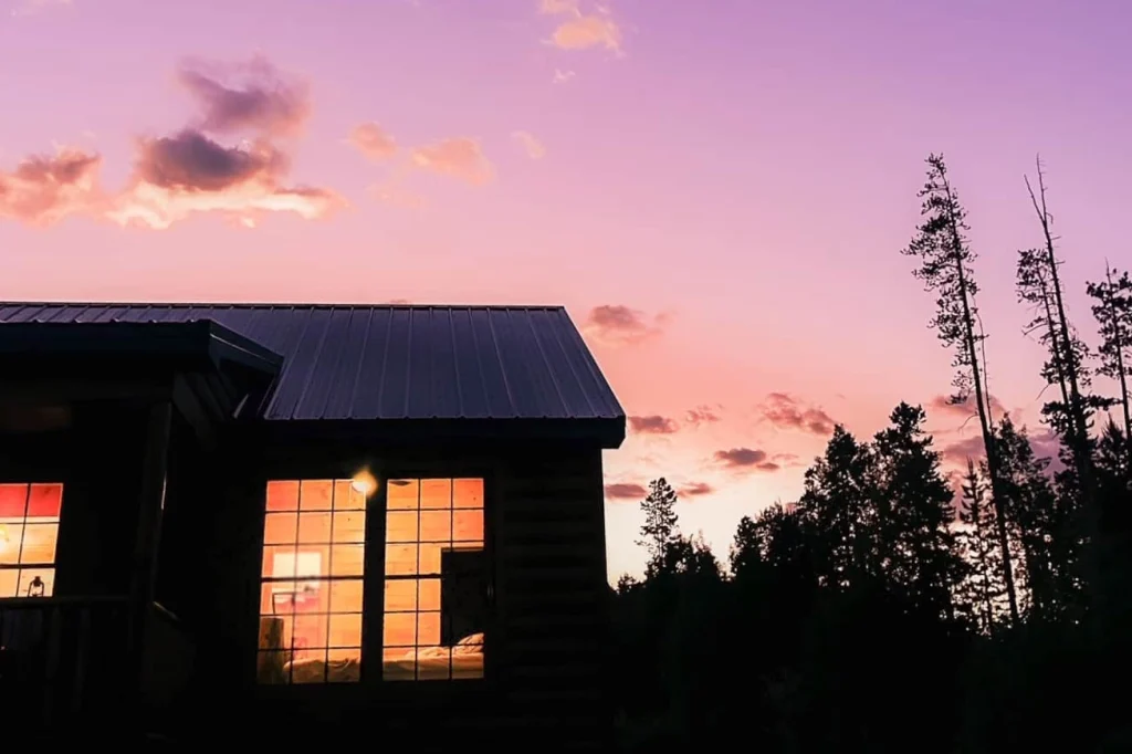 cabin window with purple sky sunset in back.